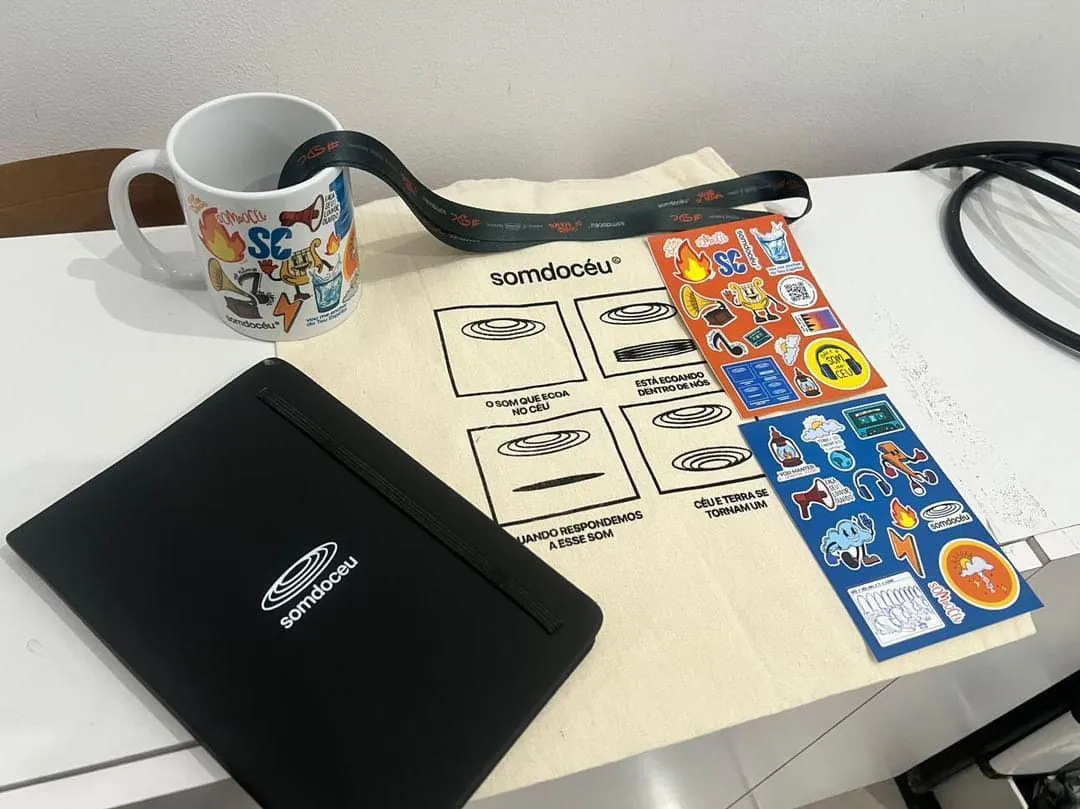 Som do Céu: Ecobag, caneca, caderneta, cordão e adesivos